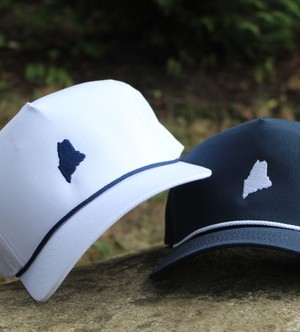 a woman sitting on the grass facing the sun, with an embroided jumper